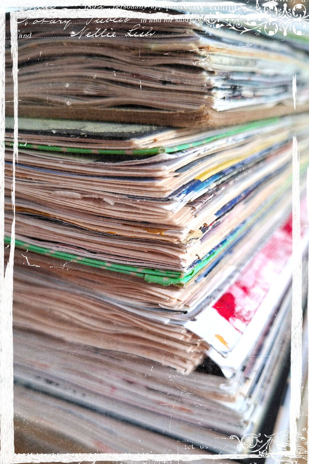 A stack of visual journals, bursting with pages and images from magazines.